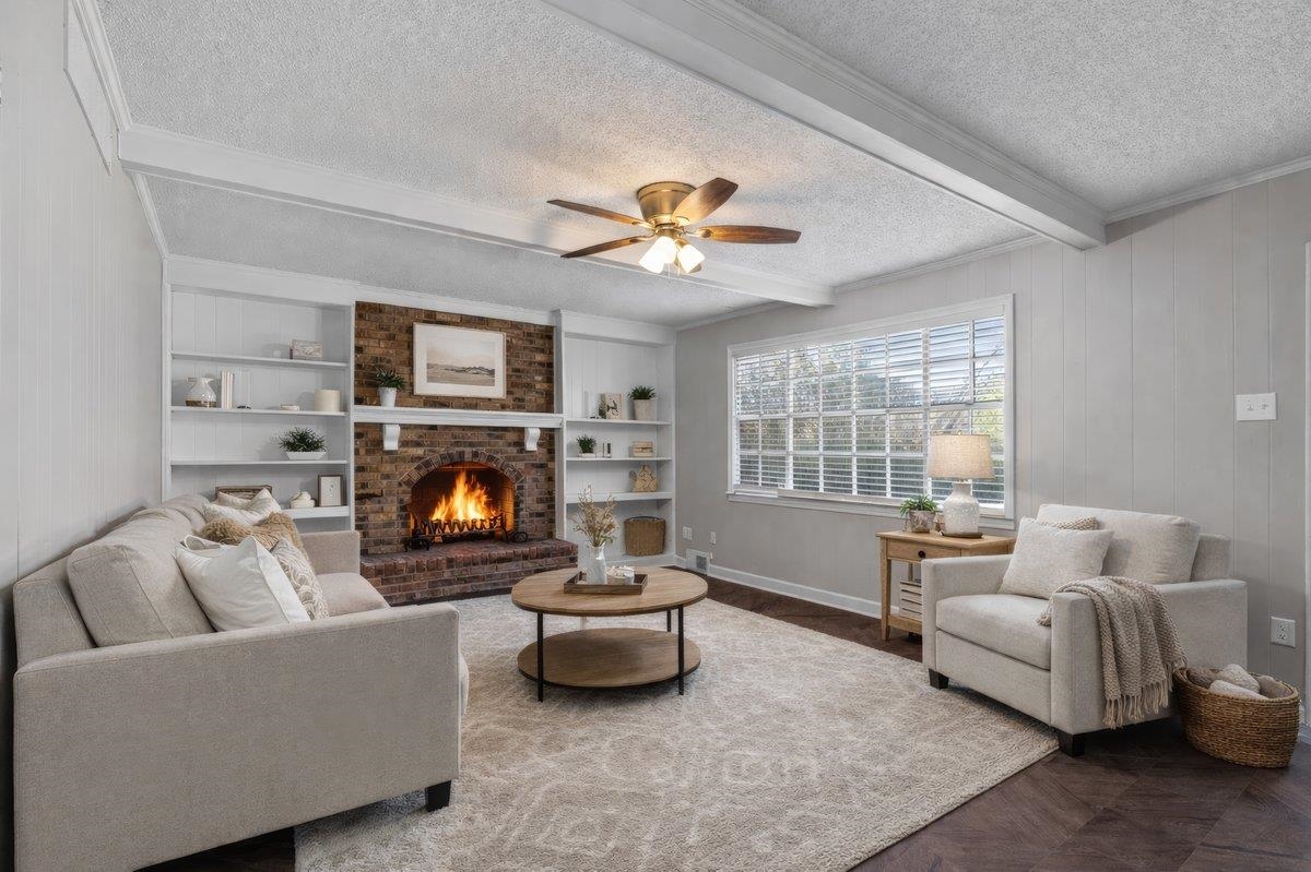 6010 Fox Ridge Drive Memphis, TN 38115 - Photo 11 of 34 Living room featuring beam ceiling, built in shelves, parquet floors, a fireplace, and a textured ceiling