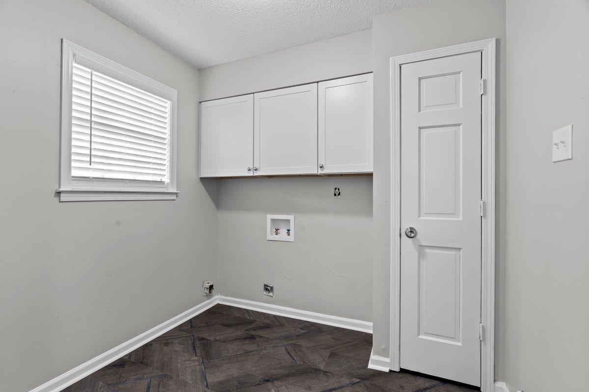 6010 Fox Ridge Drive Memphis, TN 38115 - Photo 18 of 34 Laundry room featuring cabinet space, washer hookup, a textured ceiling, hookup for an electric dryer, and parquet flooring