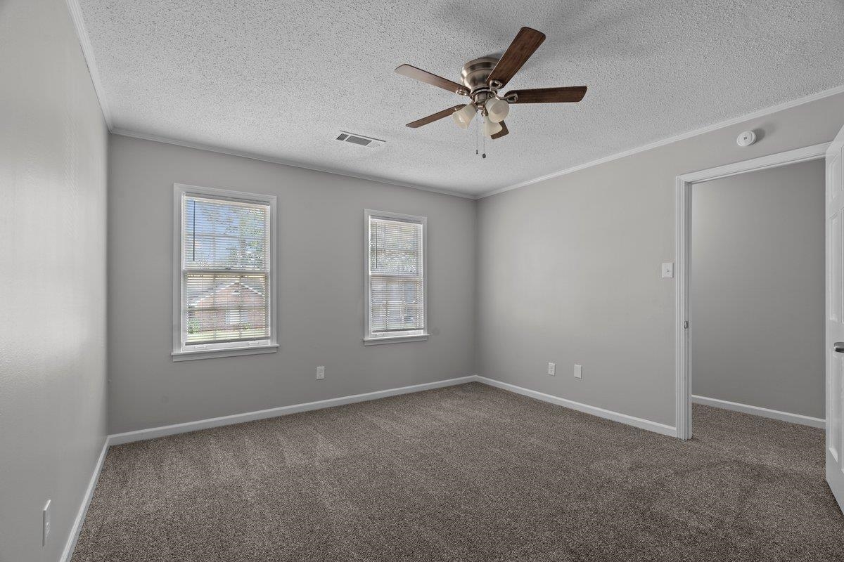 6010 Fox Ridge Drive Memphis, TN 38115 - Photo 25 of 34 Unfurnished room with dark colored carpet, ceiling fan, a textured ceiling, and ornamental molding