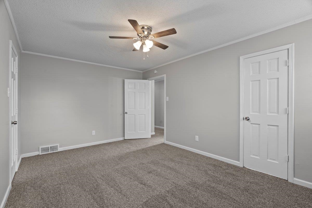 6010 Fox Ridge Drive Memphis, TN 38115 - Photo 27 of 34 Unfurnished bedroom with a textured ceiling, a ceiling fan, ornamental molding, and carpet floors
