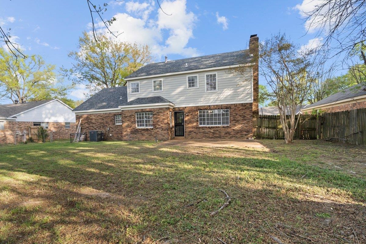 6010 Fox Ridge Drive Memphis, TN 38115 - Photo 32 of 34 Rear view of property featuring brick siding, a fenced backyard, and a chimney