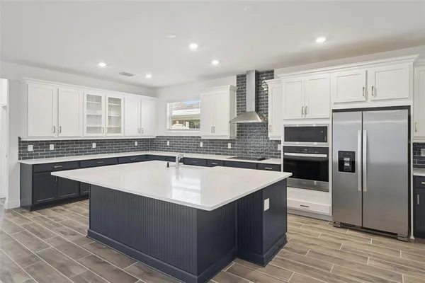 a large kitchen with stainless steel appliances granite countertop a sink counter space and cabinets