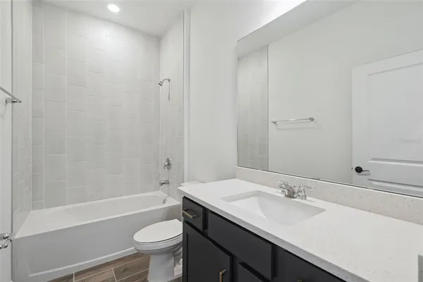 a bathroom with a sink a toilet and a large mirror