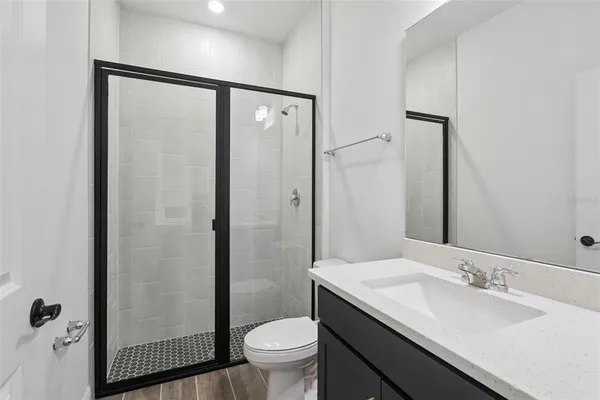 a bathroom with a granite countertop sink toilet and shower