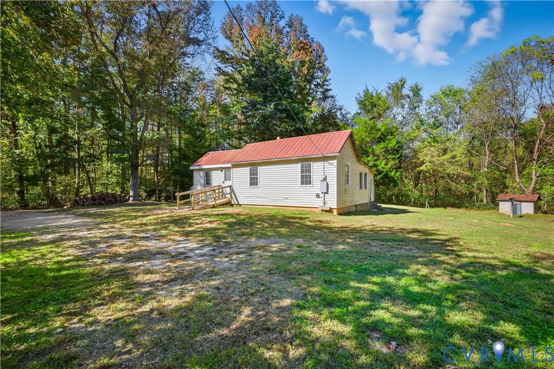 5636 Cartersville Road Powhatan, VA 23139 - Photo 4 of 32 a backyard of a house with table and chairs under an umbrella