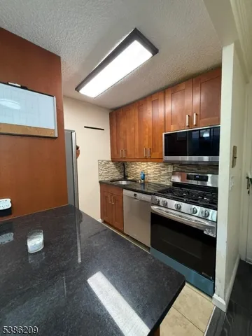 a kitchen with stainless steel appliances granite countertop a refrigerator stove and microwave