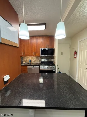 a kitchen with kitchen island a stove a sink and a microwave