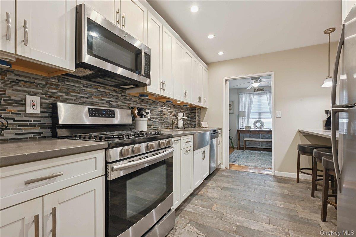700 Shore Road, Unit 4O Long Beach, NY 11561 - Photo 14 of 42 a kitchen with stainless steel appliances granite countertop a stove microwave and cabinets