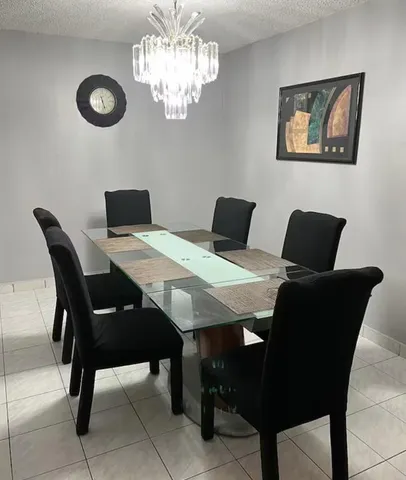 a view of a dining room with a table and chairs