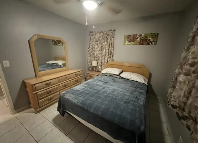 a bedroom with a bed and dresser with mirror