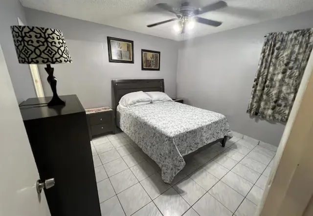 a bedroom with a bed and a lamp on the dresser