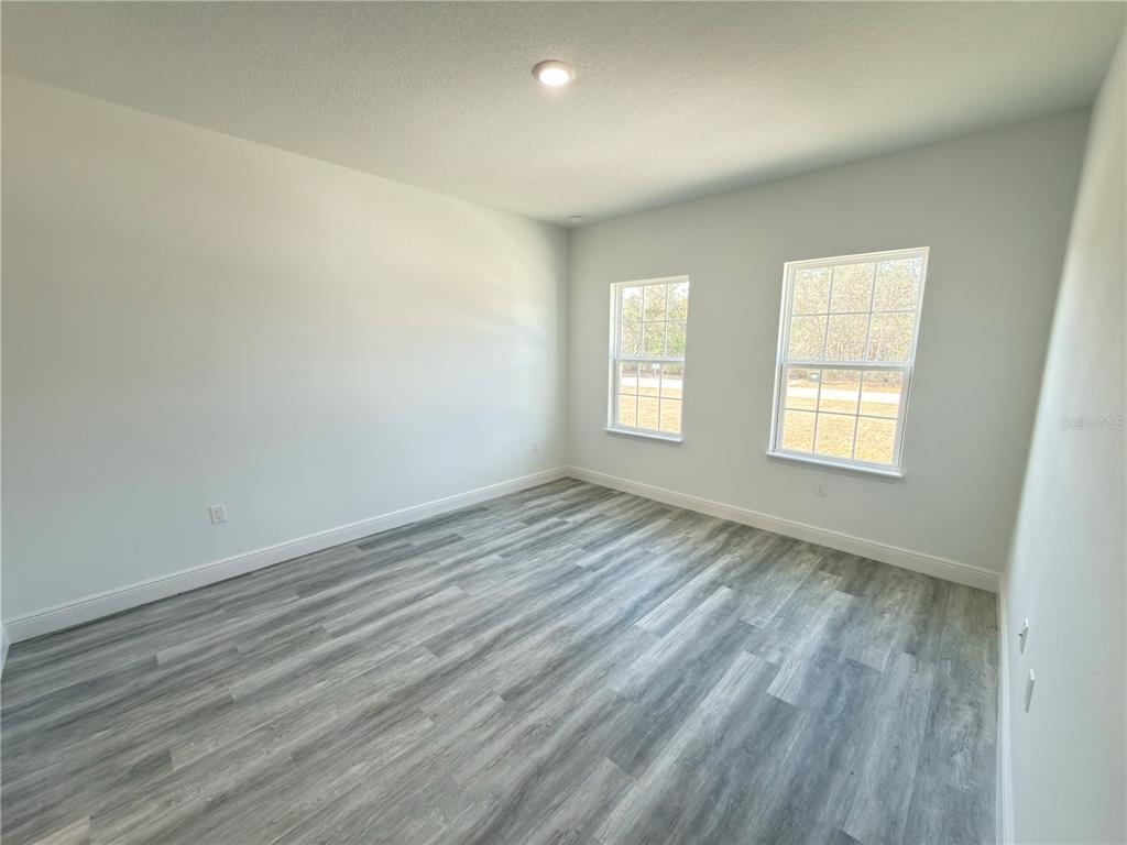 3901 Southwest 161st Loop Ocala, FL 34473 - Photo 12 of 47 an empty room with wooden floor and windows