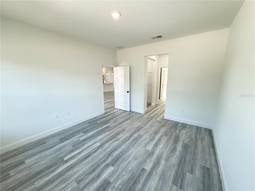 3901 Southwest 161st Loop Ocala, FL 34473 - Photo 13 of 47 an empty room with wooden floor and windows