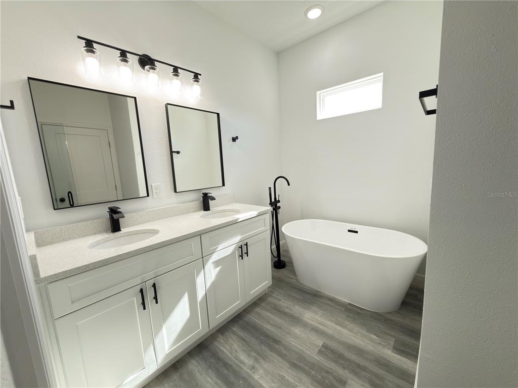 3901 Southwest 161st Loop Ocala, FL 34473 - Photo 19 of 47 a spacious bathroom with a double vanity sink mirror and bathtub