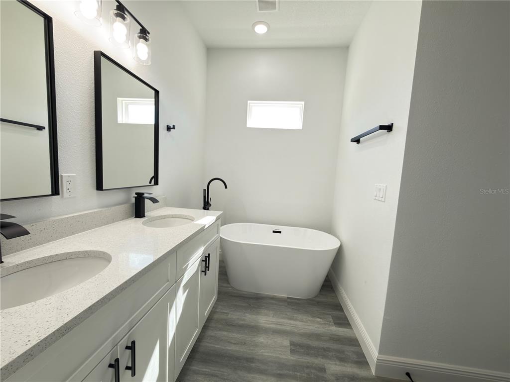 3901 Southwest 161st Loop Ocala, FL 34473 - Photo 20 of 47 a spacious bathroom with a double vanity sink a mirror and a bathtub