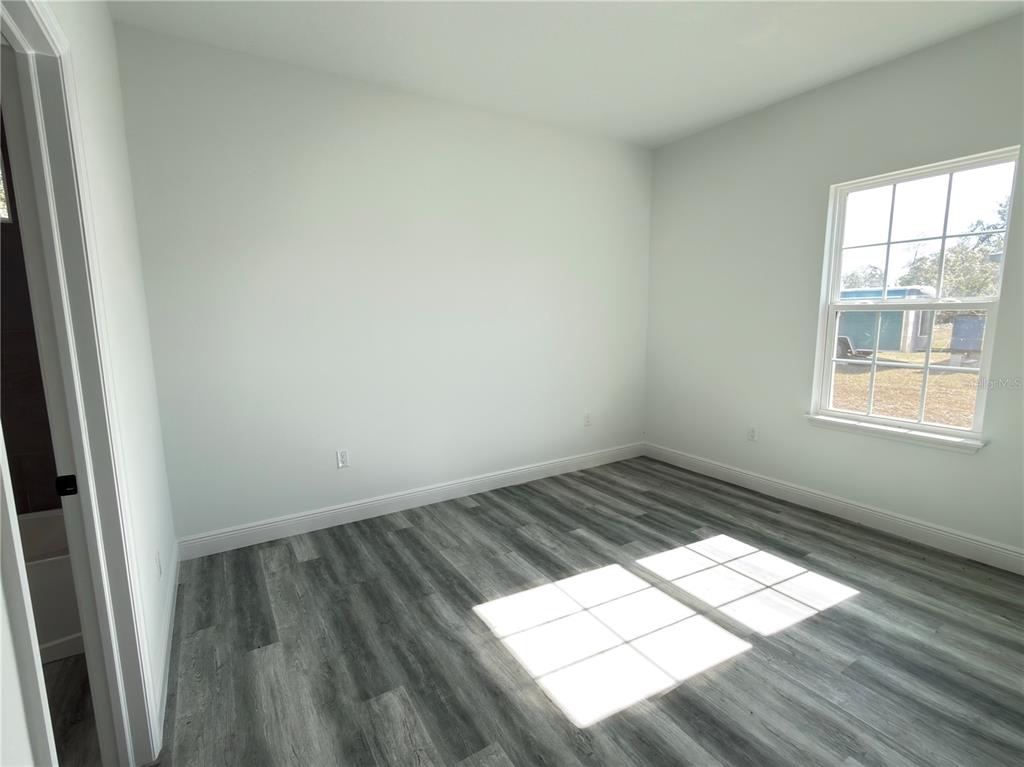 3901 Southwest 161st Loop Ocala, FL 34473 - Photo 27 of 47 an empty room with wooden floor and windows