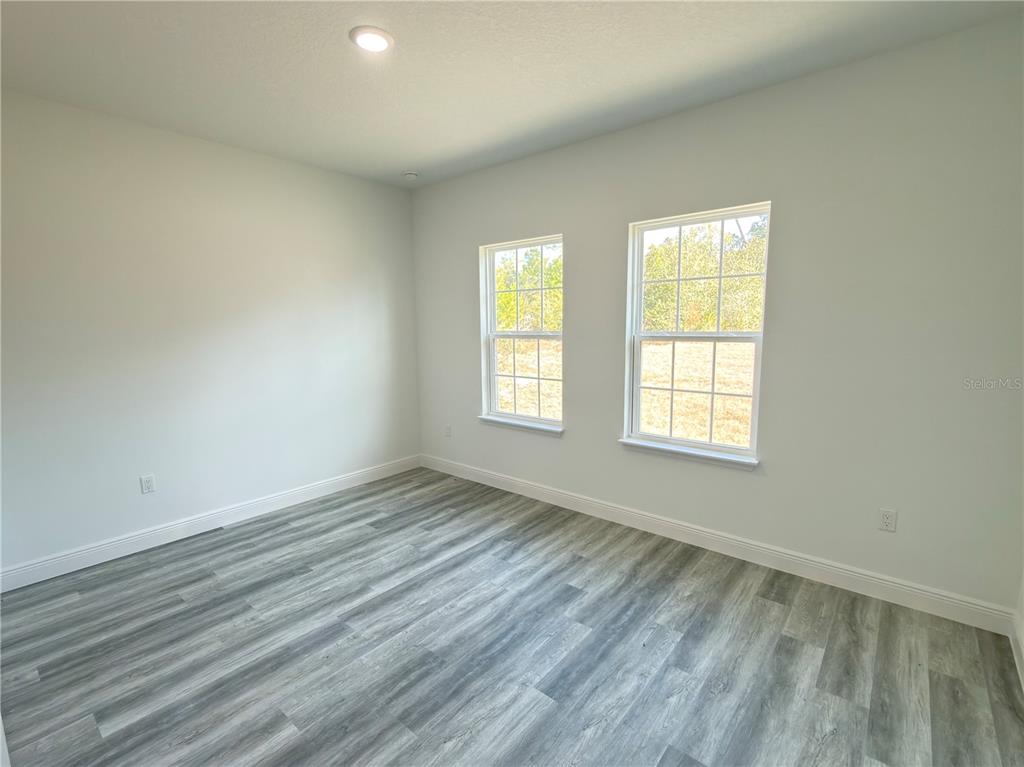 3901 Southwest 161st Loop Ocala, FL 34473 - Photo 31 of 47 an empty room with wooden floor and windows