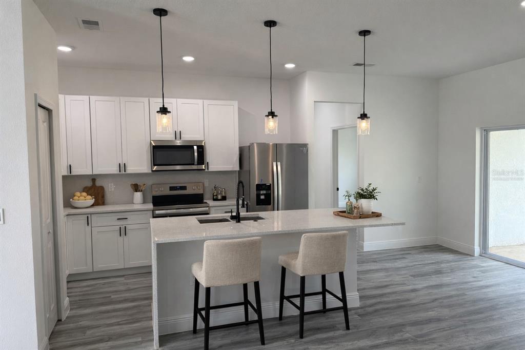 3901 Southwest 161st Loop Ocala, FL 34473 - Photo 4 of 47 a kitchen with kitchen island white cabinets and stainless steel appliances