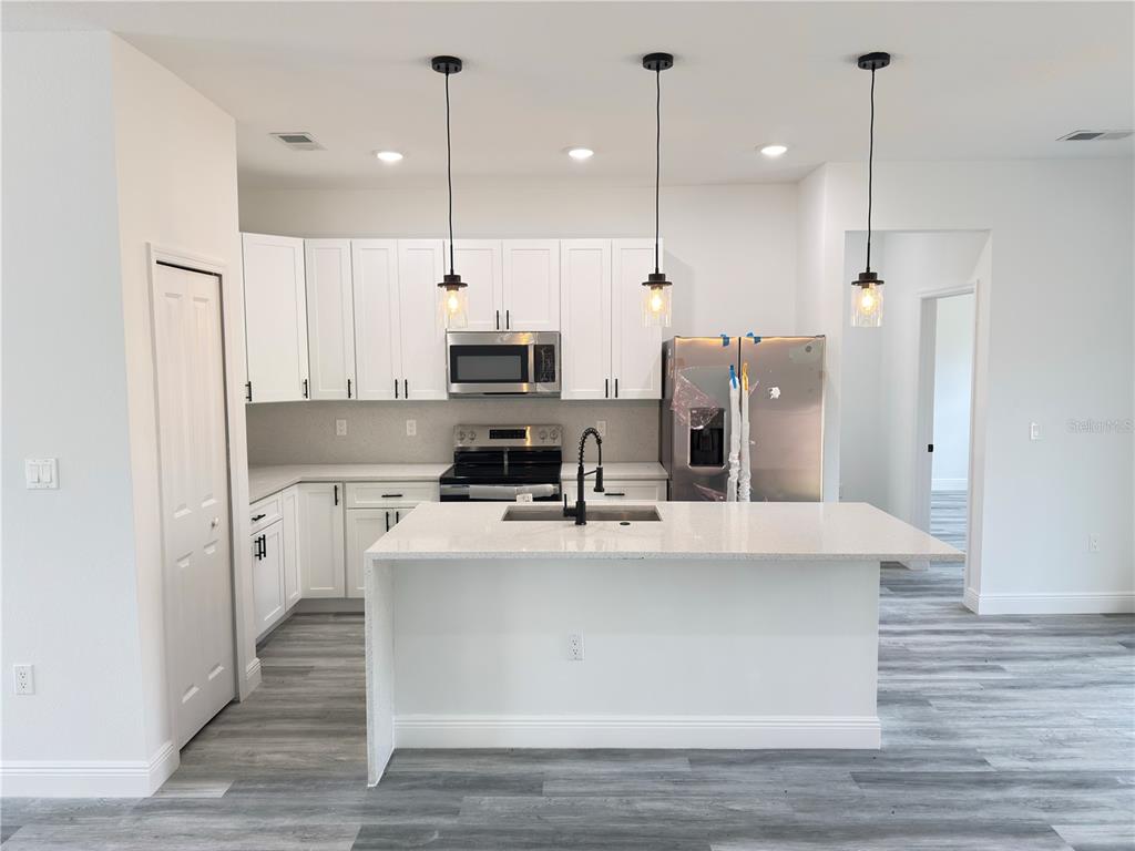 3901 Southwest 161st Loop Ocala, FL 34473 - Photo 5 of 47 a large white kitchen with stainless steel appliances