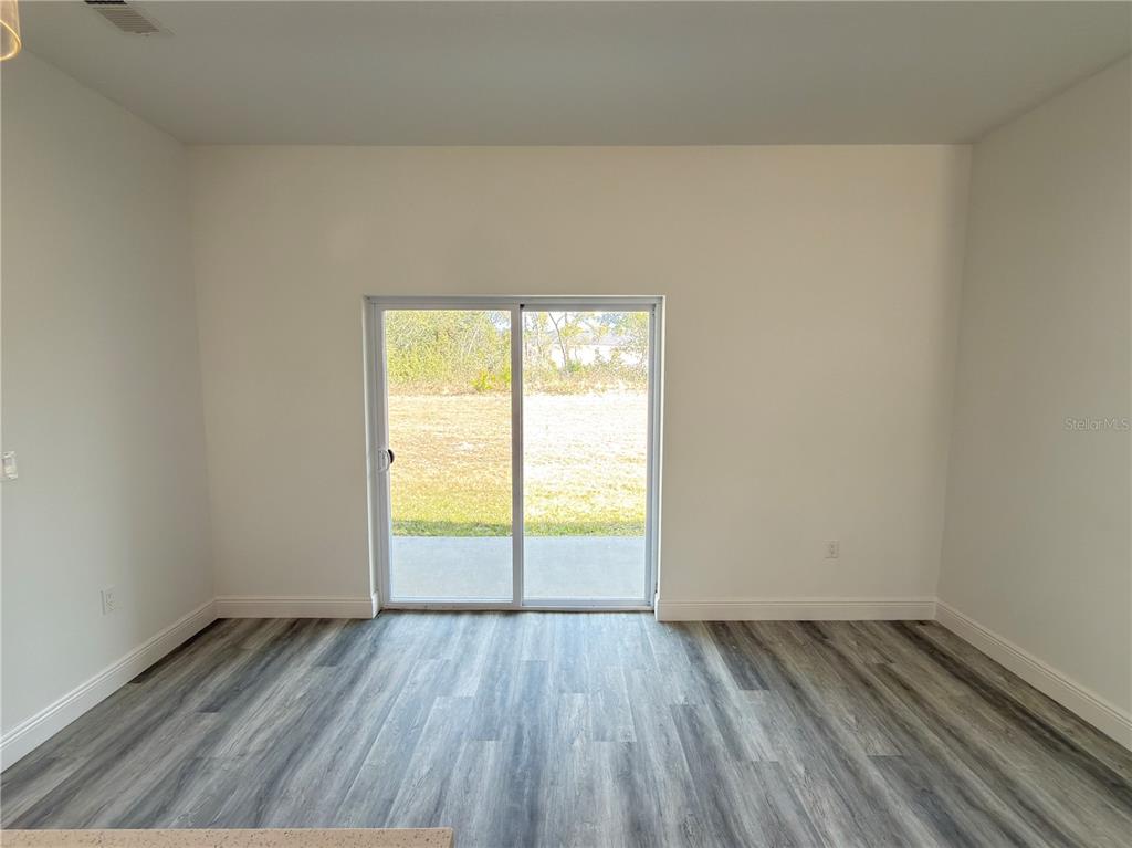 3901 Southwest 161st Loop Ocala, FL 34473 - Photo 10 of 47 an empty room with wooden floor and windows
