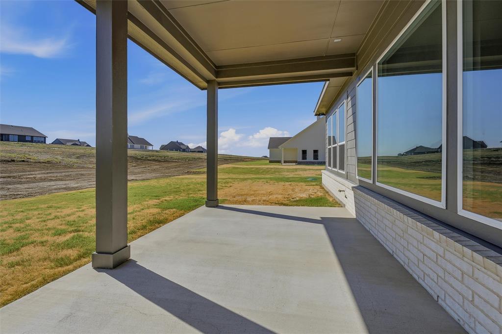 153 Big Sky Road Decatur, TX 76234 - Photo 33 of 38 Covered patio with concrete flooring, multiple large windows, and a white brick foundation