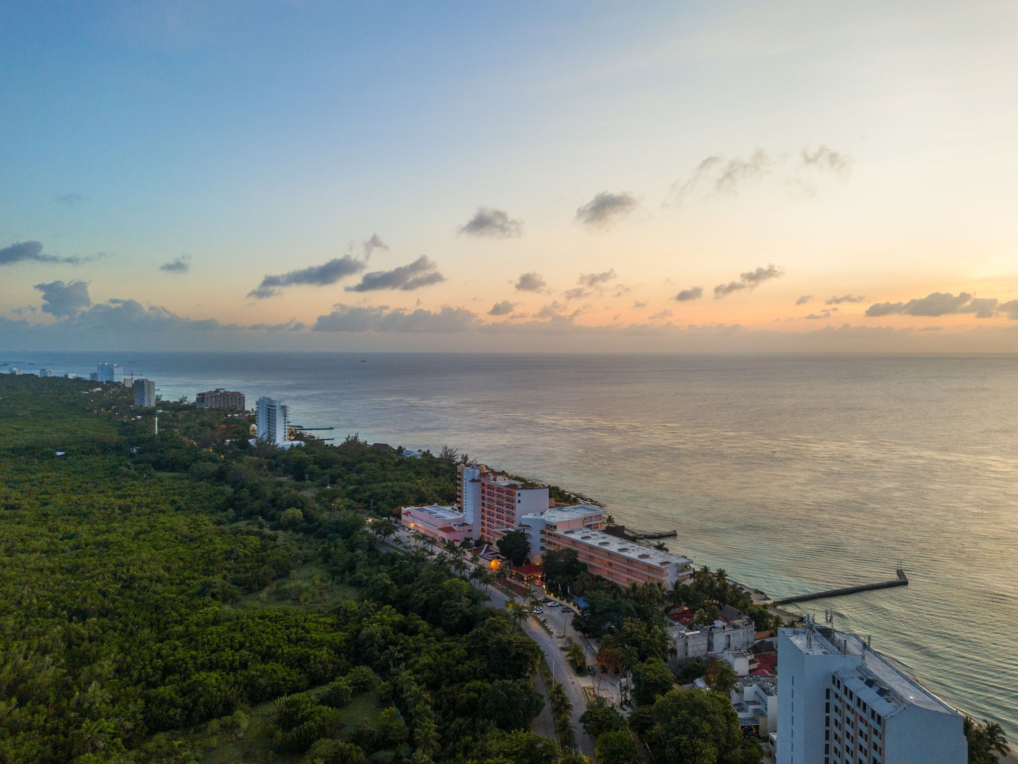 6 Country Club, Unit 4 Nome, TX 77629 - Photo 33 of 45 A breathtaking coastal drone shot captures Cozumel’s iconic shoreline at dusk, illustrating the vibrant tropical lifestyle waiting just minutes from your private villa doorstep.