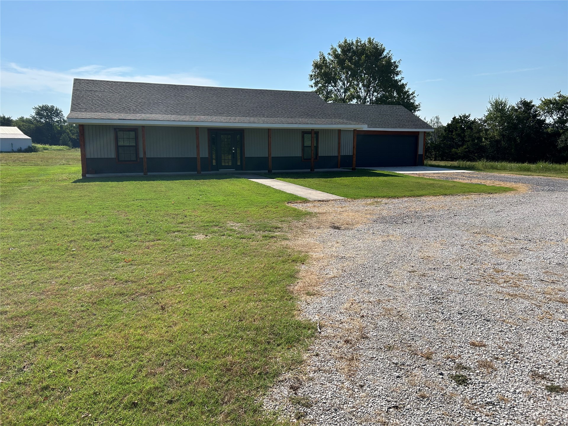 190 South 3 Mile Road Fort Gibson, OK 74434 - Photo 14 of 35 Single-story residence featuring a dark gray roof, light gray siding, and a covered porch with wood-finish columns