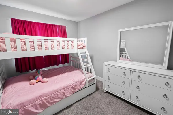 a bedroom with a bed a dresser and a mirror