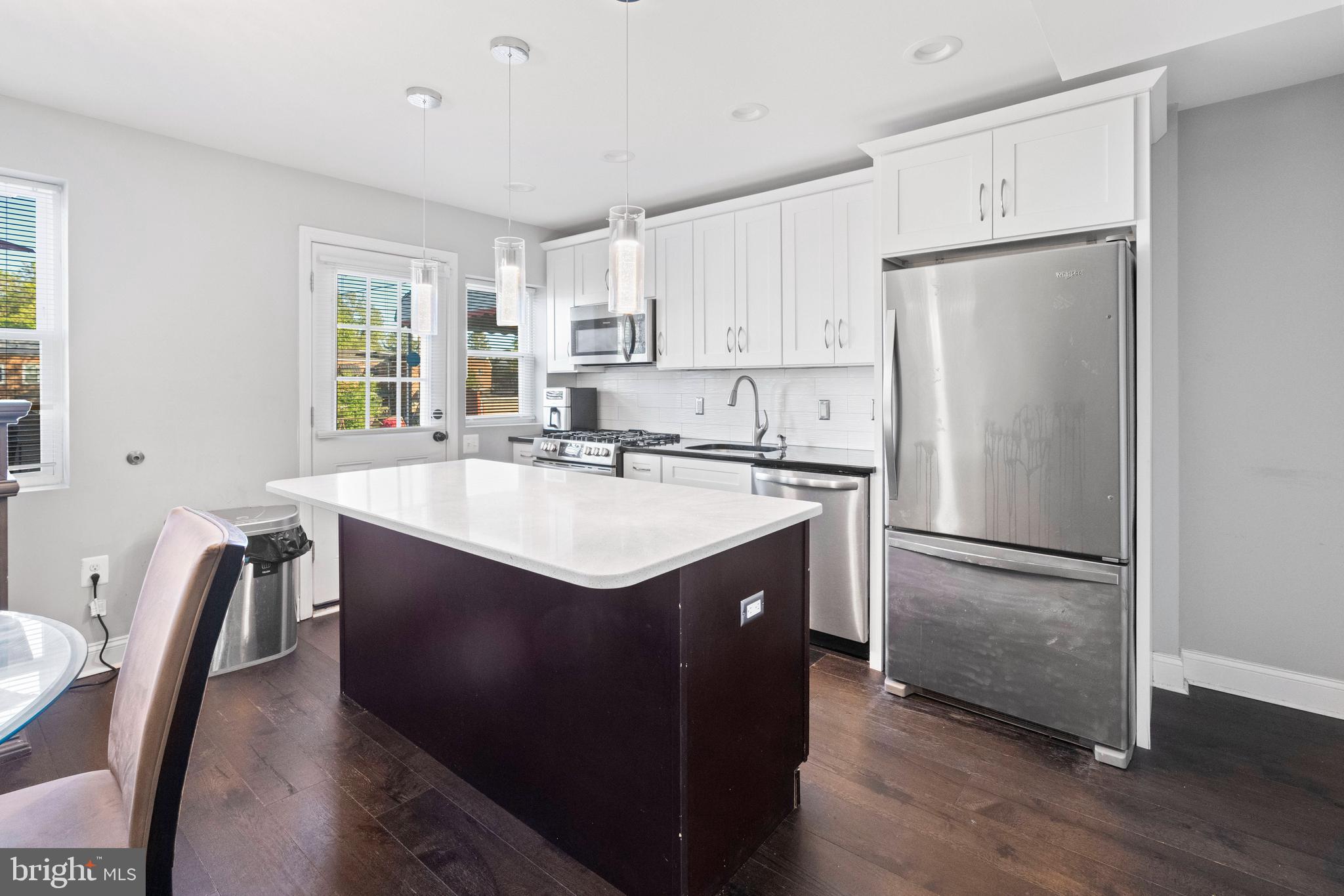 4237 Flowerton Road Baltimore, MD 21229 - Photo 5 of 27 a kitchen with stainless steel appliances a sink a refrigerator and white cabinets