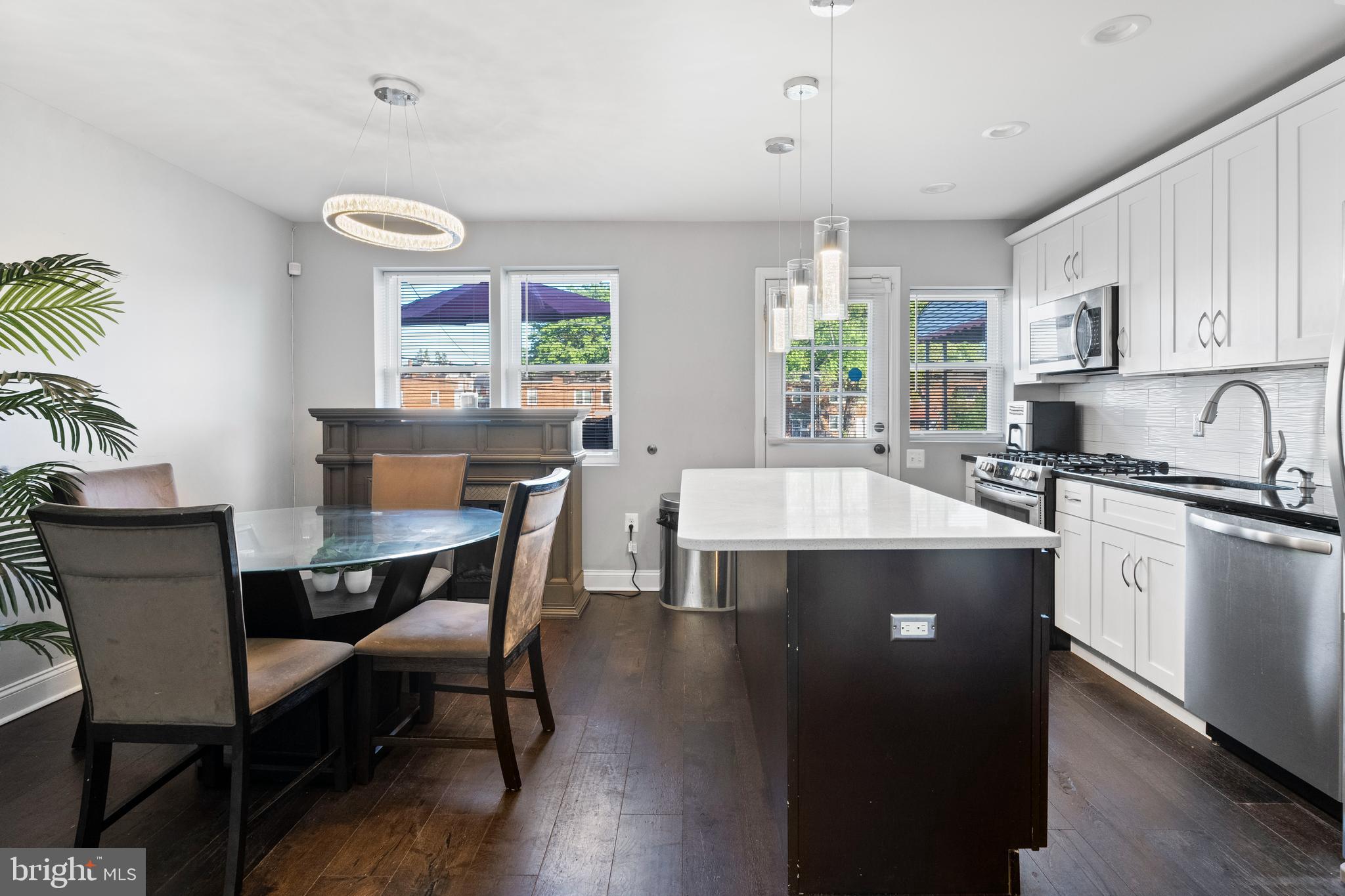 4237 Flowerton Road Baltimore, MD 21229 - Photo 8 of 27 a kitchen with a table chairs stove and cabinets