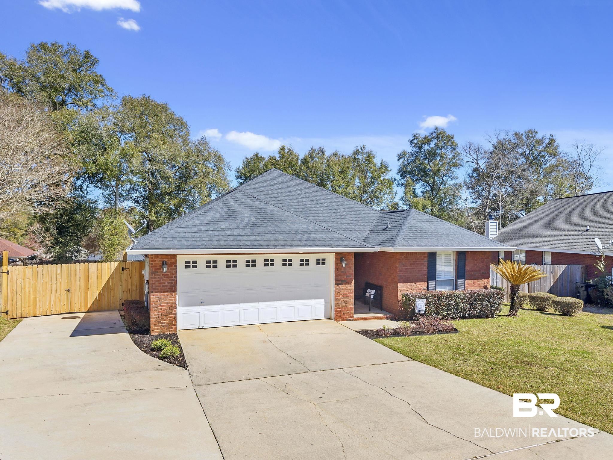 11103 Pontchartrain Loop Daphne, AL 36526 - Photo 1 of 29 Single story home featuring brick siding, fence, concrete driveway, a front yard, and a garage