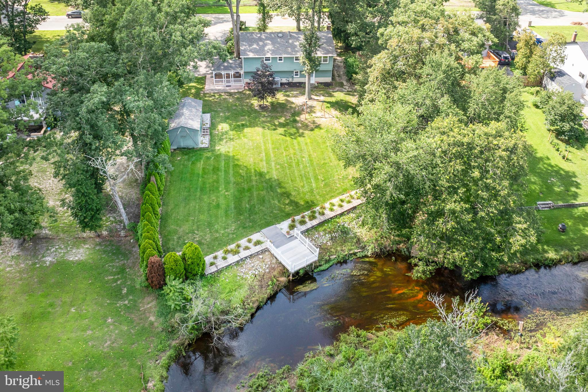 an aerial view of residential houses with outdoor space and trees