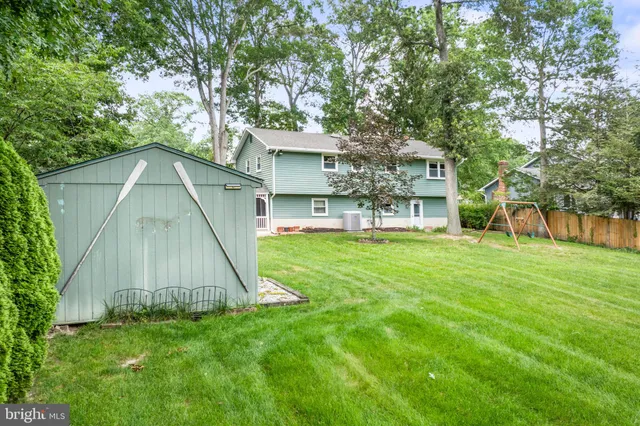 a view of a big house with a big yard and large tree