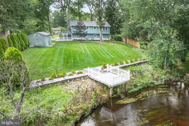 a view of a water pond with green yard