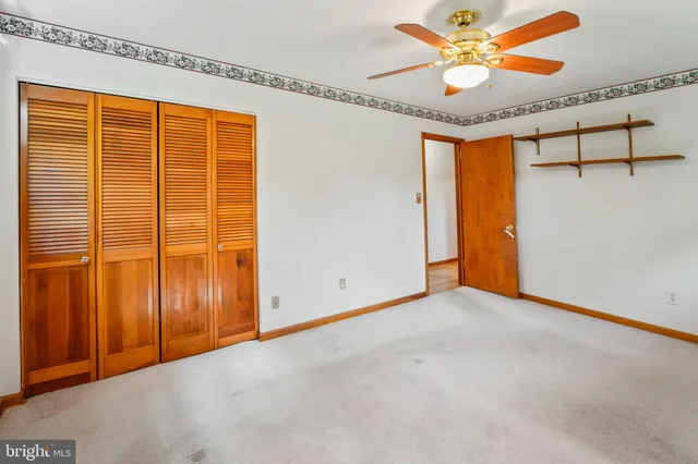 an empty room with a ceiling fan and a window