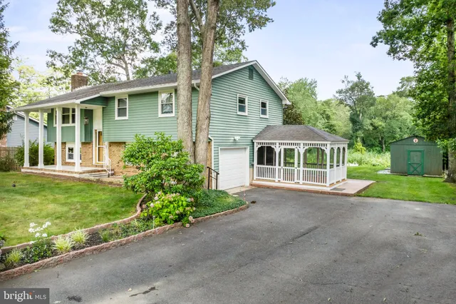 a front view of a house with a garden and trees