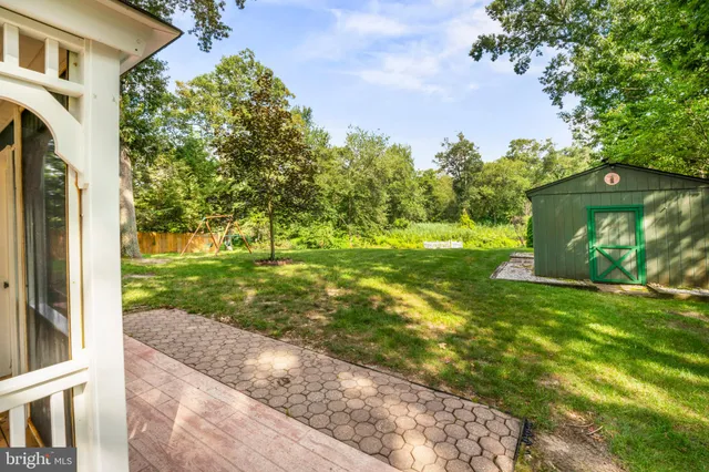 a view of a yard with plants and a brick wall