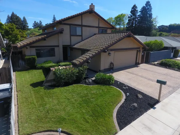an aerial view of a house with garden space and street view