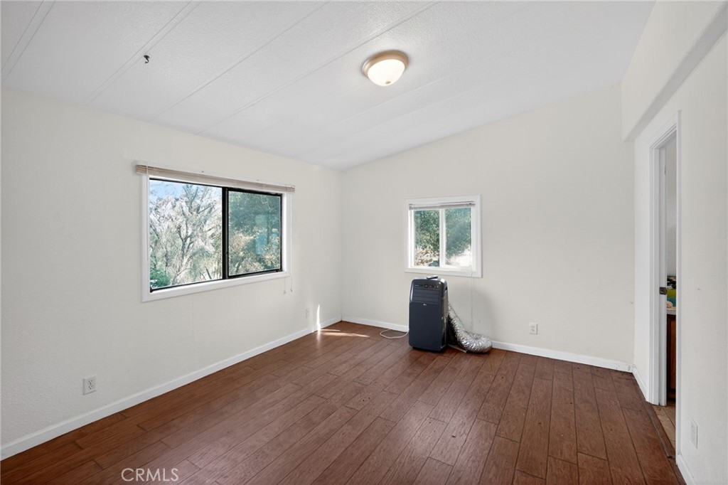 3804 Owl Creek Road Mariposa, CA 95338 - Photo 11 of 18 an empty room with wooden floor and windows