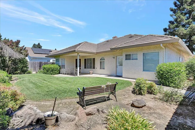 a view of a backyard with table and chairs potted plants and wooden fence