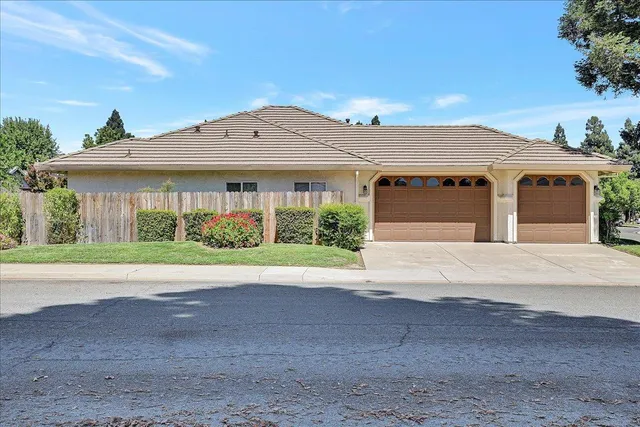 a front view of a house with a yard and potted plants