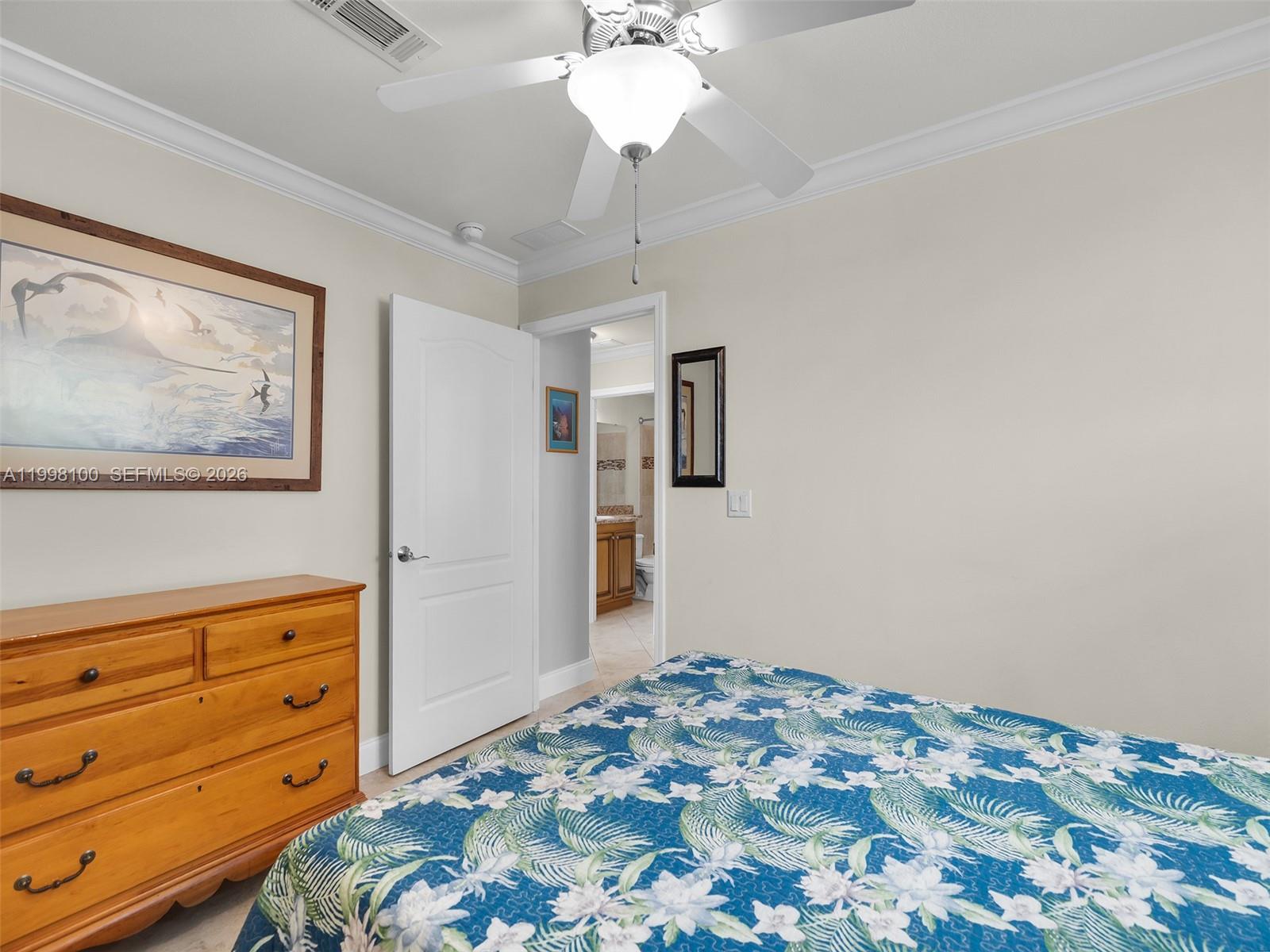 437 Pirates Road Summerland Key, FL 33042 - Photo 30 of 39 a bedroom with a bed and a chandelier