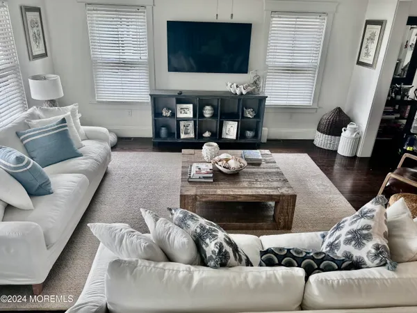 a living room with furniture a flat screen tv and a window