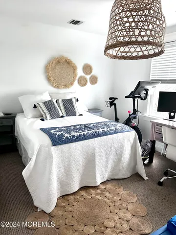 a bed sitting in a bedroom next to a window and a potted plant