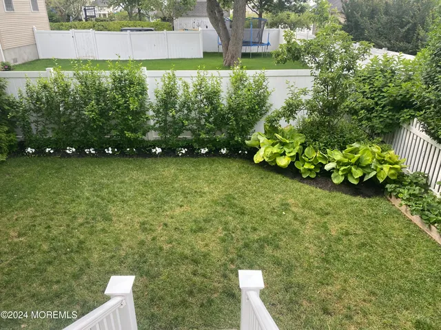a backyard of a house with lots of green space and plants