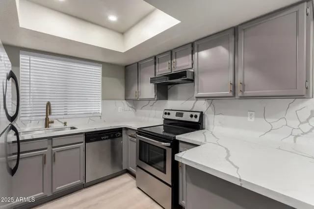 a kitchen with stainless steel appliances a sink stove and cabinets