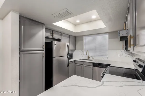 a kitchen with a sink a refrigerator and cabinets