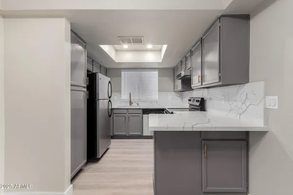 a kitchen with a sink a refrigerator and cabinets