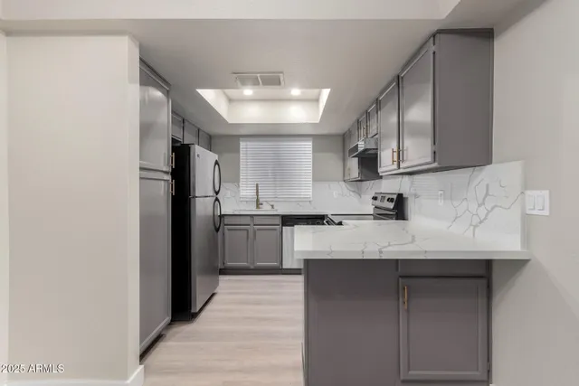 a kitchen with a sink a refrigerator and cabinets