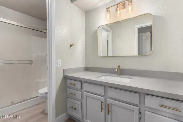 a bathroom with a granite countertop sink a toilet and a mirror